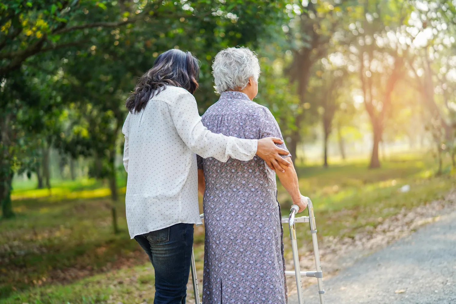 Hilfe und Pflege Asiatische Senioren oder ältere Frauen nutzen einen Gehhilfe mit guter Gesundheit, während sie in einem fröhlichen, frischen Urlaub im Park spazieren gehen.